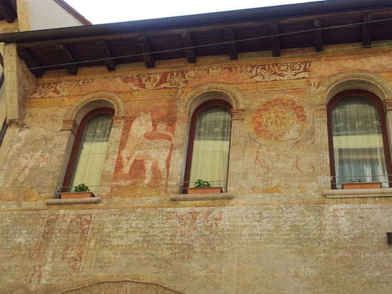 Gli affreschi sulla facciata di un antico edificio nel centro di Treviso