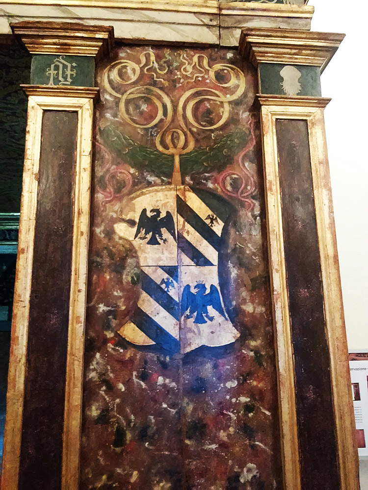 Detalle de la entrada: obsérvese el escudo de Feltresco que cuelga de la guirnalda y, en las pilastras, las iniciales FF a la izquierda y la empresa de granadas a la derecha.