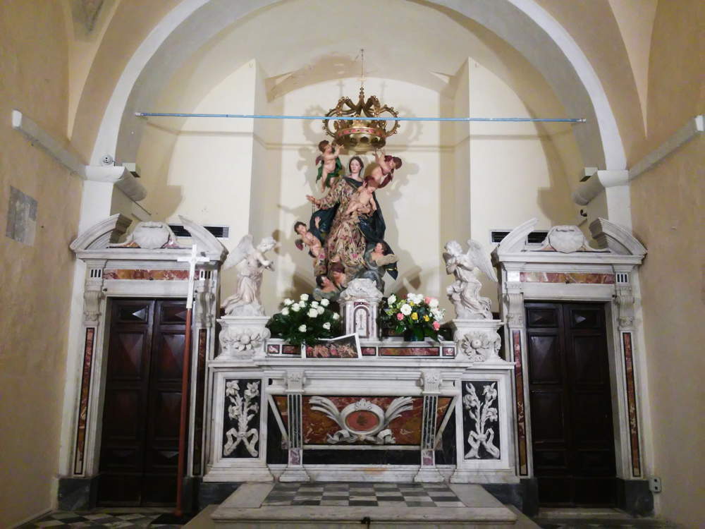 La Virgen del Rosario detrás del altar del siglo XVII en el Baptisterio de la Catedral de Carrara.