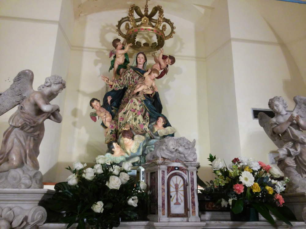 Nuestra Señora del Rosario detrás de los ángeles del altar