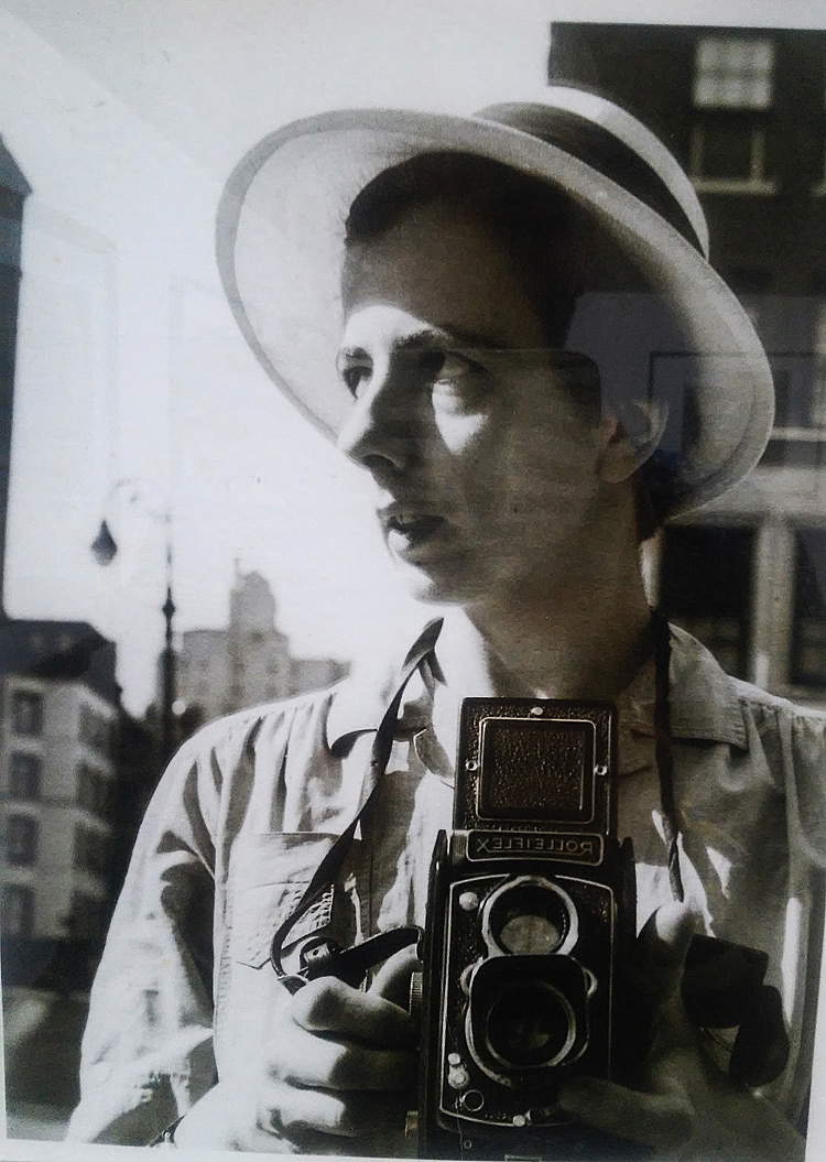 1930S DONNA SORRIDENTE CHE TIENE LA MACCHINA FOTOGRAFICA SEDUTA