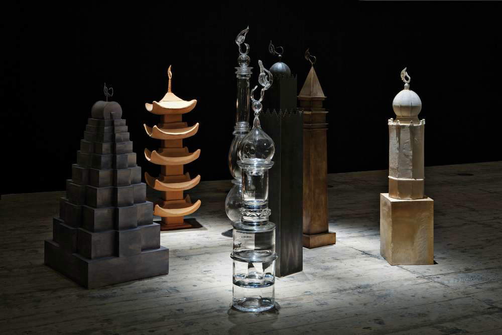 Moataz Nasr, The Tower of Love (2011; 7 towers, including 2 ceramic towers of 175 x 49 x 49 cm and 172 x 38 x 38 cm, 1 iron tower of 192 x 28 x 28 cm, 1 bronze tower of 190 x 35 x 35 cm, 2 crystal towers of 173 x 33 x 33 cm and 212 x 41 x 41 cm, and 1 wooden tower of 155 x 89 x 69 cm). Ph. Credit Ela Bialkowska