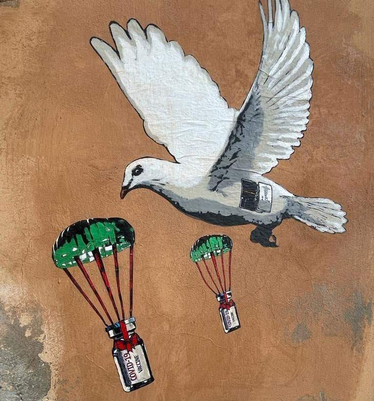 Street art, a dove brings vaccines to the Ministry of Health