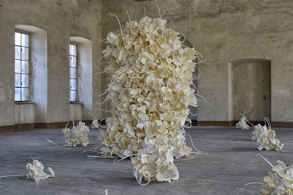 Biella, Cracking Art porta una grande installazione di 400 fiori di plastica in un'azienda tessile