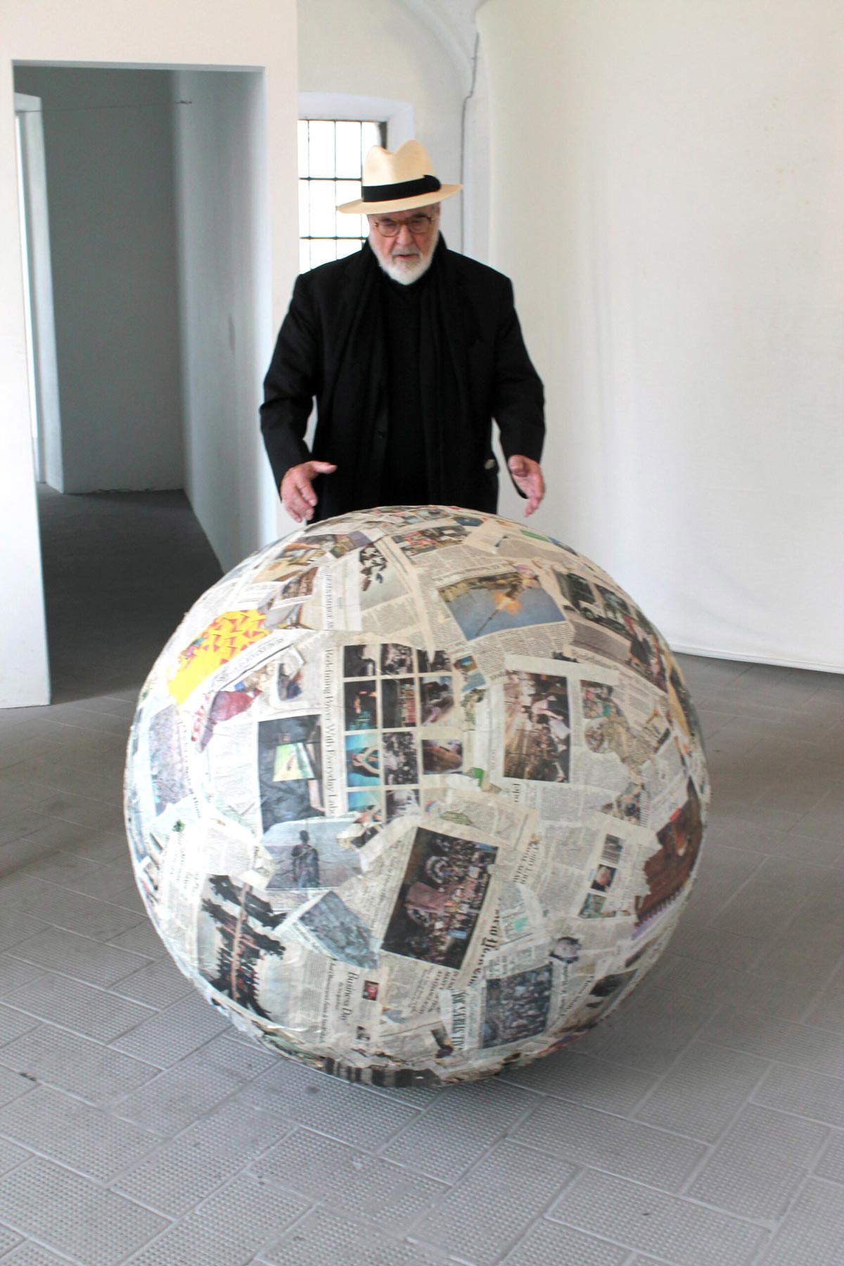 Michelangelo Pistoletto ritratto con la sua opera Sfera di giornali (1966 - 2017; giornali pressati, 100 x 100 cm). Foto A. Lacirasella
