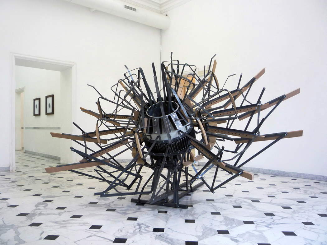 Alberto Tadiello, Tarantolata (2012 ; bétonnière portable, profils métalliques, lattes en mdf, vis, boulons, 300 x 250 x 200 cm). Alberto Tadiello, Tarantolata (2012 ; bétonnière portable, profils métalliques, lattes en mdf, vis, boulons, 300 x 250 x 200 cm).