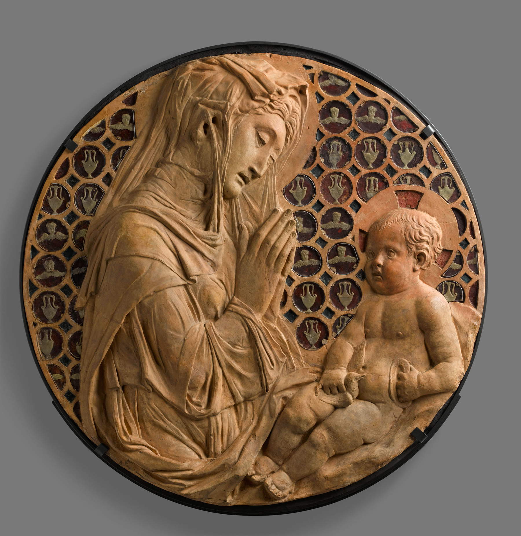 Donatello, Madonna col Bambino detta Madonna Piot (1440 circa; terracotta già dorata, cera, paste vitree, 74 x 75 x 7 cm; Parigi, Musée du Louvre, Département des Sculptures du Moyen Âge, de la Renaissance et des temps modernes, inv. RF 3967). Foto di Stéphane Maréchalle Donatello, Madonna col Bambino detta Madonna Piot (1440 circa; terracotta già dorata, cera, paste vitree, 74 x 75 x 7 cm; Parigi, Musée du Louvre, Département des Sculptures du Moyen Âge, de la Renaissance et des temps modernes, inv. RF 3967). Foto di Stéphane Maréchalle