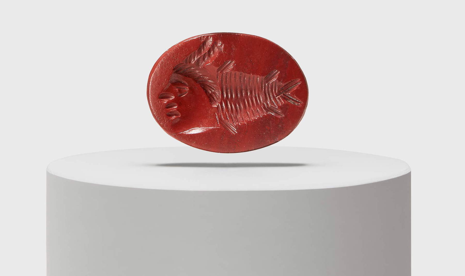 Art romain, gemme avec grylle composée d'un poisson et d'un visage humain (IIe siècle après J.-C. ; jaspe rouge ; Aquilée, Musée national). Photo par Slowphoto, MAN Aquileia archive Art romain, gemme avec grylle composée d'un poisson et d'un visage humain (IIe siècle après J.-C. ; jaspe rouge ; Aquilée, Musée national). Photo par Slowphoto, MAN Aquileia archive