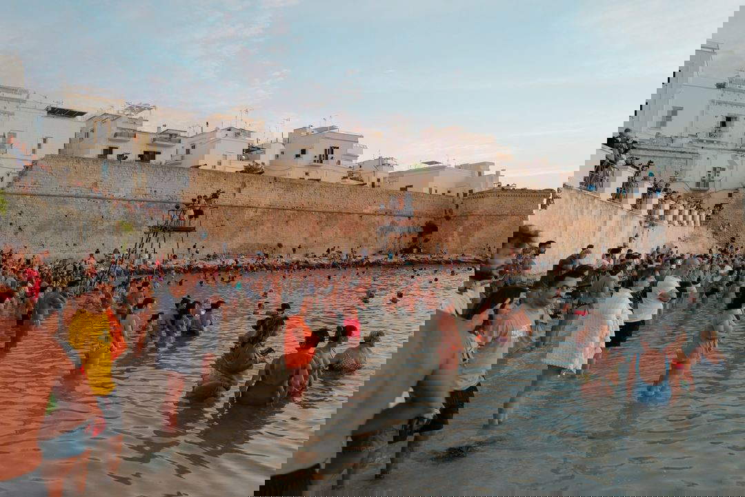 Il bagno all'alba a Monopoli. Foto di Piero Percoco e Mirko Ostuni