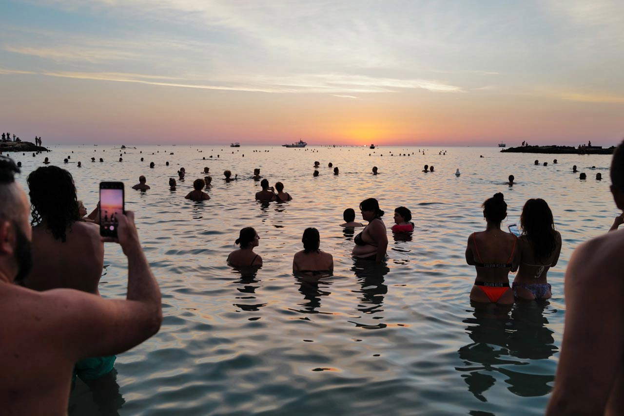 Il bagno all'alba a Monopoli. Foto di Piero Percoco e Mirko Ostuni