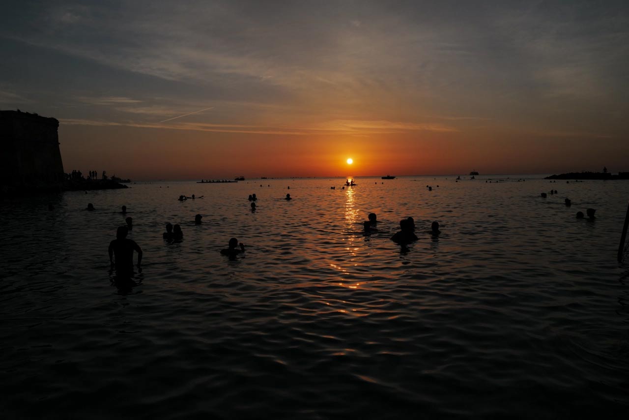 Il bagno all'alba a Monopoli. Foto di Piero Percoco e Mirko Ostuni