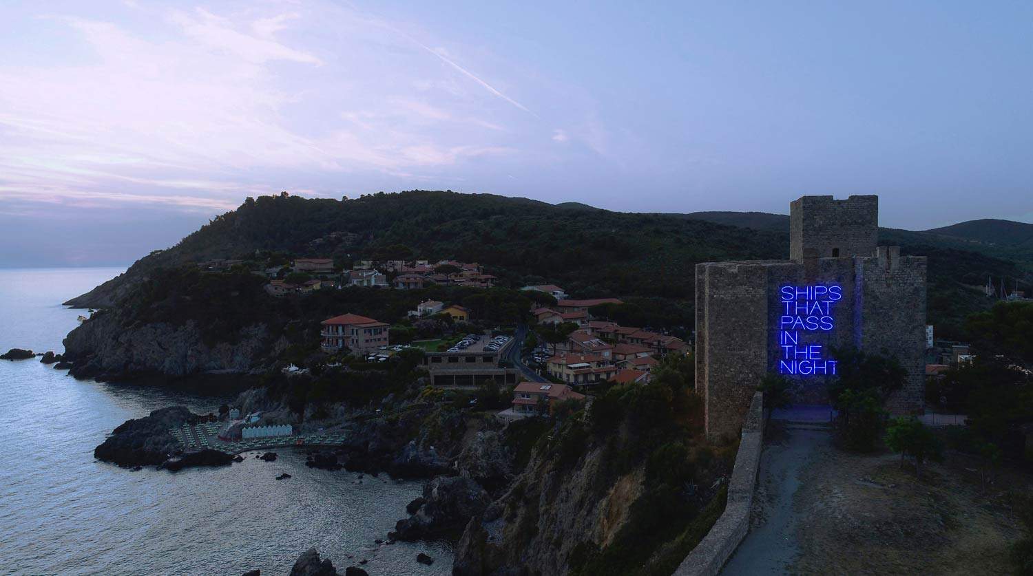 A large neon light on the Fortress of Talamone. Maurizio Nannucci's work for Hypermaremma.