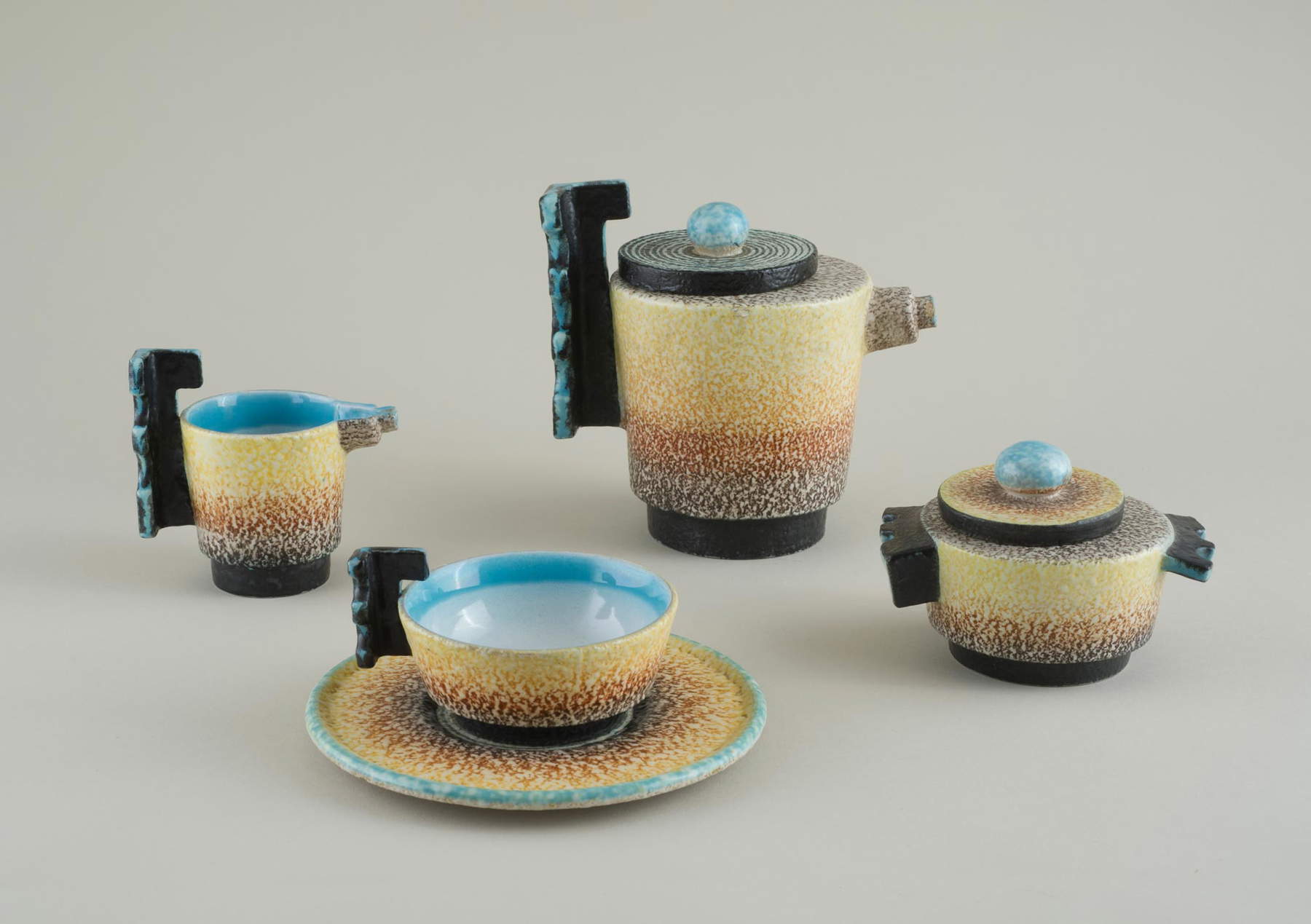 Nicolaj Diulgheroff, Teeservice für sechs Personen (1932-1933; glasiertes Steingut, Teekanne 16 x 17,5 cm, Milchkännchen 10 x 12 cm, Zuckerdose 9 x 12,5 cm, Untertasse Durchmesser 16,5 cm; Savona, Museo della Ceramica). Foto: Fulvio Rosso Nicolaj Diulgheroff, Teeservice für sechs Personen (1932-1933; glasiertes Steingut, Teekanne 16 x 17,5 cm, Milchkännchen 10 x 12 cm, Zuckerdose 9 x 12,5 cm, Untertasse Durchmesser 16,5 cm; Savona, Museo della Ceramica). Foto: Fulvio Rosso