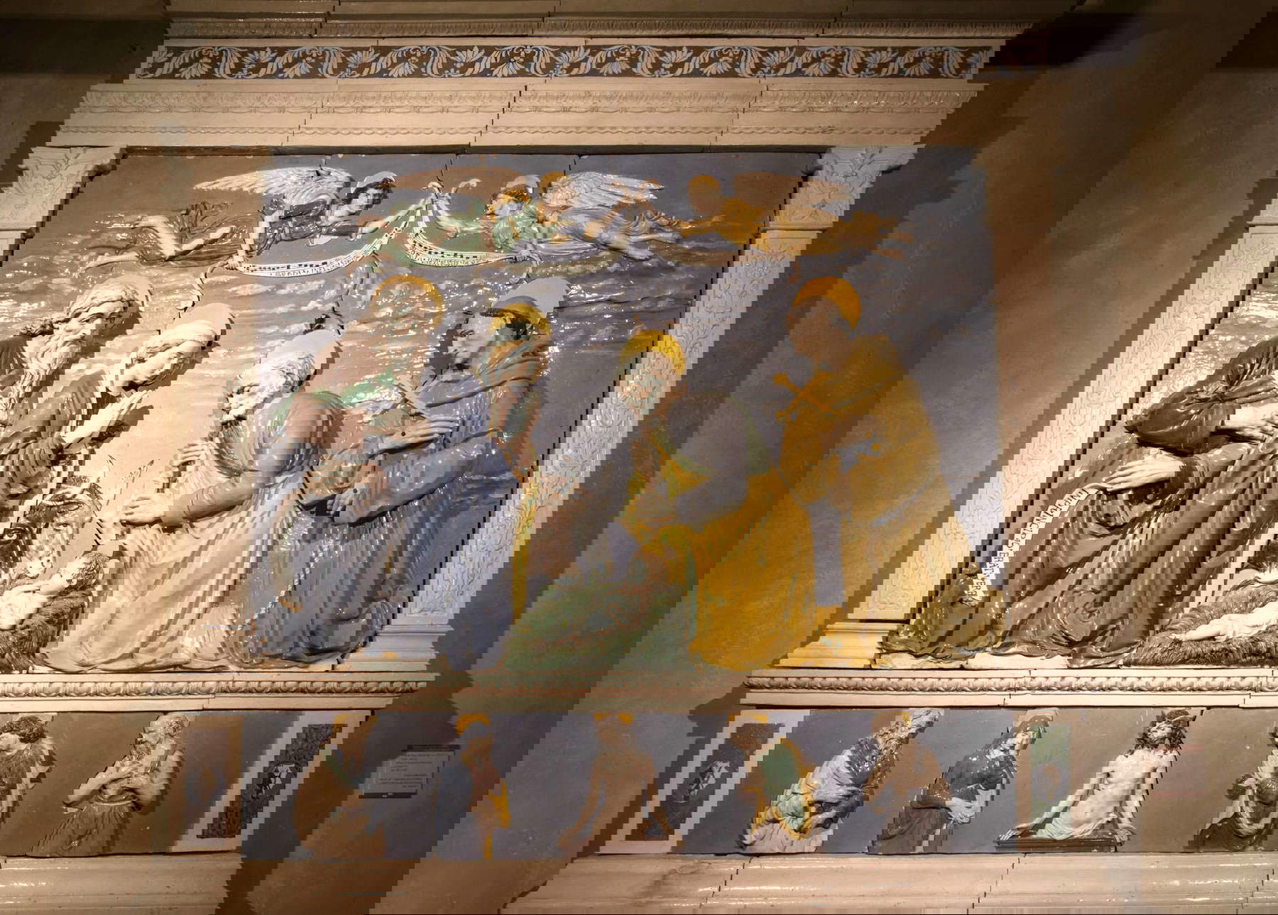 Andrea della Robbia, Nativité entre les saints Jean l'Évangéliste et François (vers 1490-1500 ; terre cuite vernissée ; Anghiari, Museo di Palazzo Taglieschi)