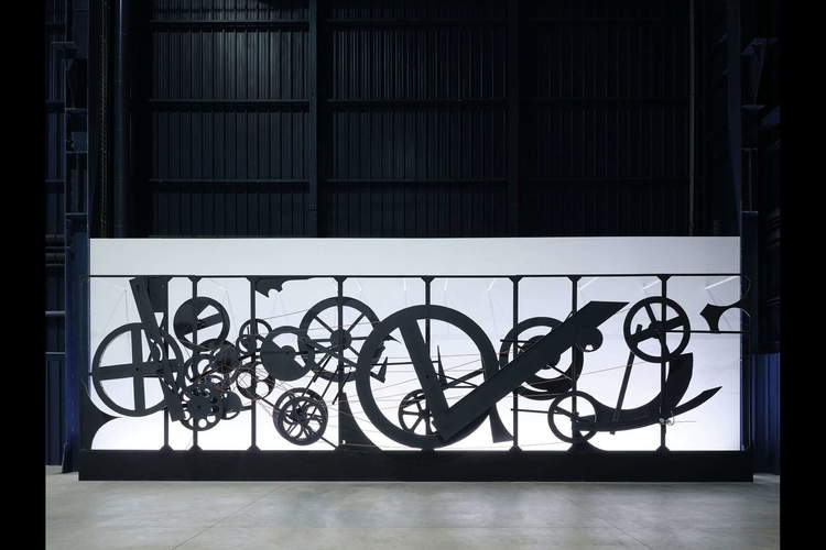 Jean Tinguely, Requiem pour une feuille morte (1967 ; structure en acier, roues en bois et en métal, courroies en cuir, peinture noire, feuille soudée peinte en blanc, moteur électrique, 305 x 1150 x 80 cm ; Collection Fonds Renault pour l'art et la culture)