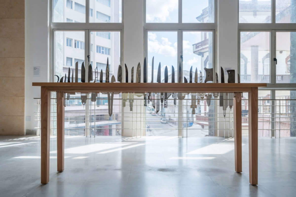 Carlos Garaicoa, Las Raíces del Mundo (2018 ; bâtiments en acier inoxydable, couteaux, 118 x 200 x 50 cm) Carlos Garaicoa, Las Raíces del Mundo (2018 ; bâtiments en acier inoxydable, couteaux, 118 x 200 x 50 cm)