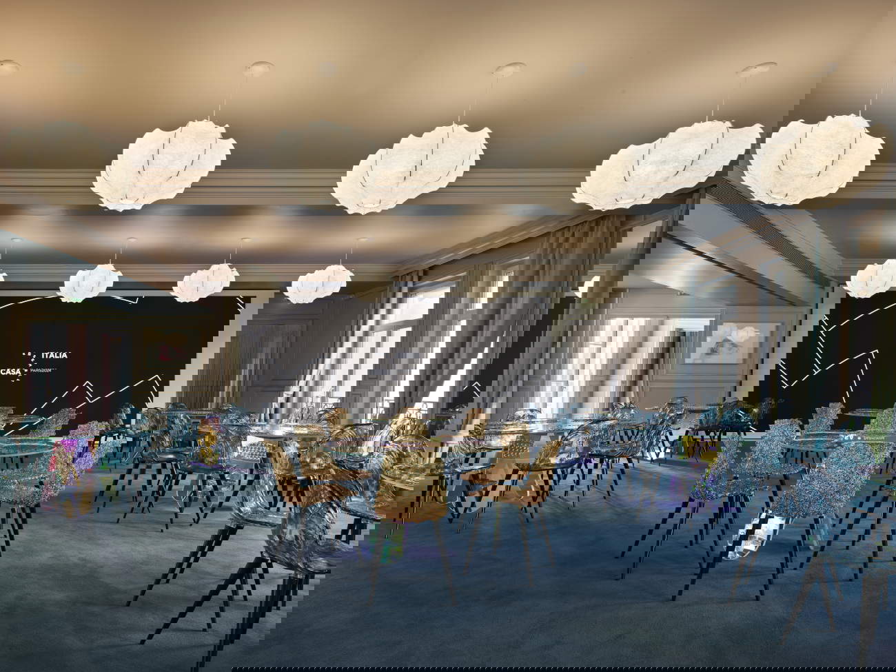 Installation view sala hospitality. Arredi: tavoli Shimmer by Patricia Urquiola per Glas Italia, sedie Gilda B. e Gina by Jacopo Foggini per Edra e sospensioni Viscontea by Achille e Pier Giacomo Castiglioni per Flos, tende Rubelli. Foto di Pietro Savorelli per CONI