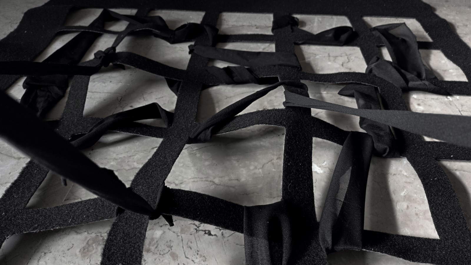 Giulia Nelli, Tu che ne sai (2024 ; collants noirs de différentes densités et tissus, installation spécifique au site, dimensions environnementales). Giulia Nelli, Tu che ne sai (2024 ; collants noirs de différentes densités et tissus, installation spécifique au site, dimensions environnementales).