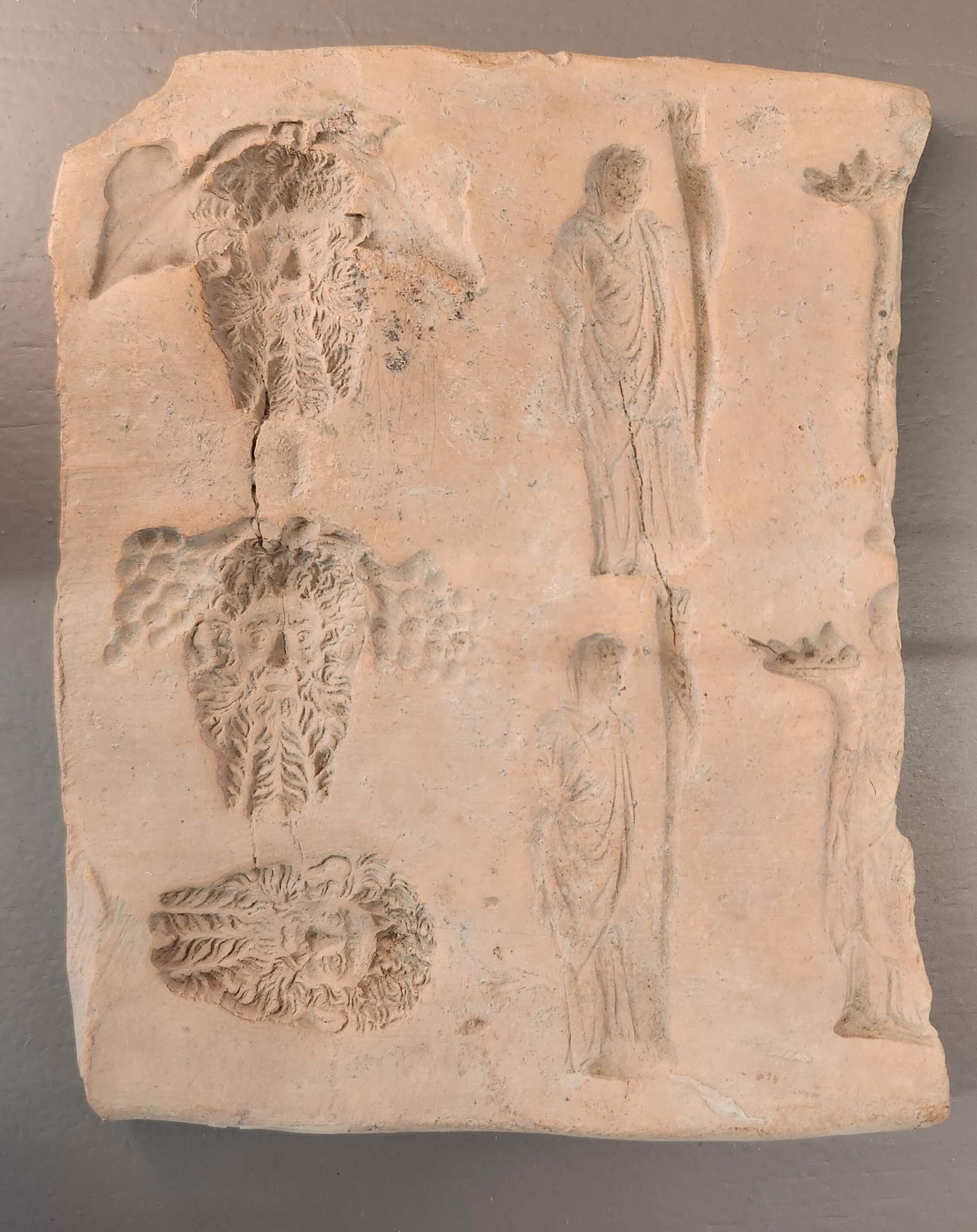 Matriz de placa con máscaras y figuras de pie. Colección Gamurrini &copy; MiC- Dirección Regional Museos Nacionales Toscana