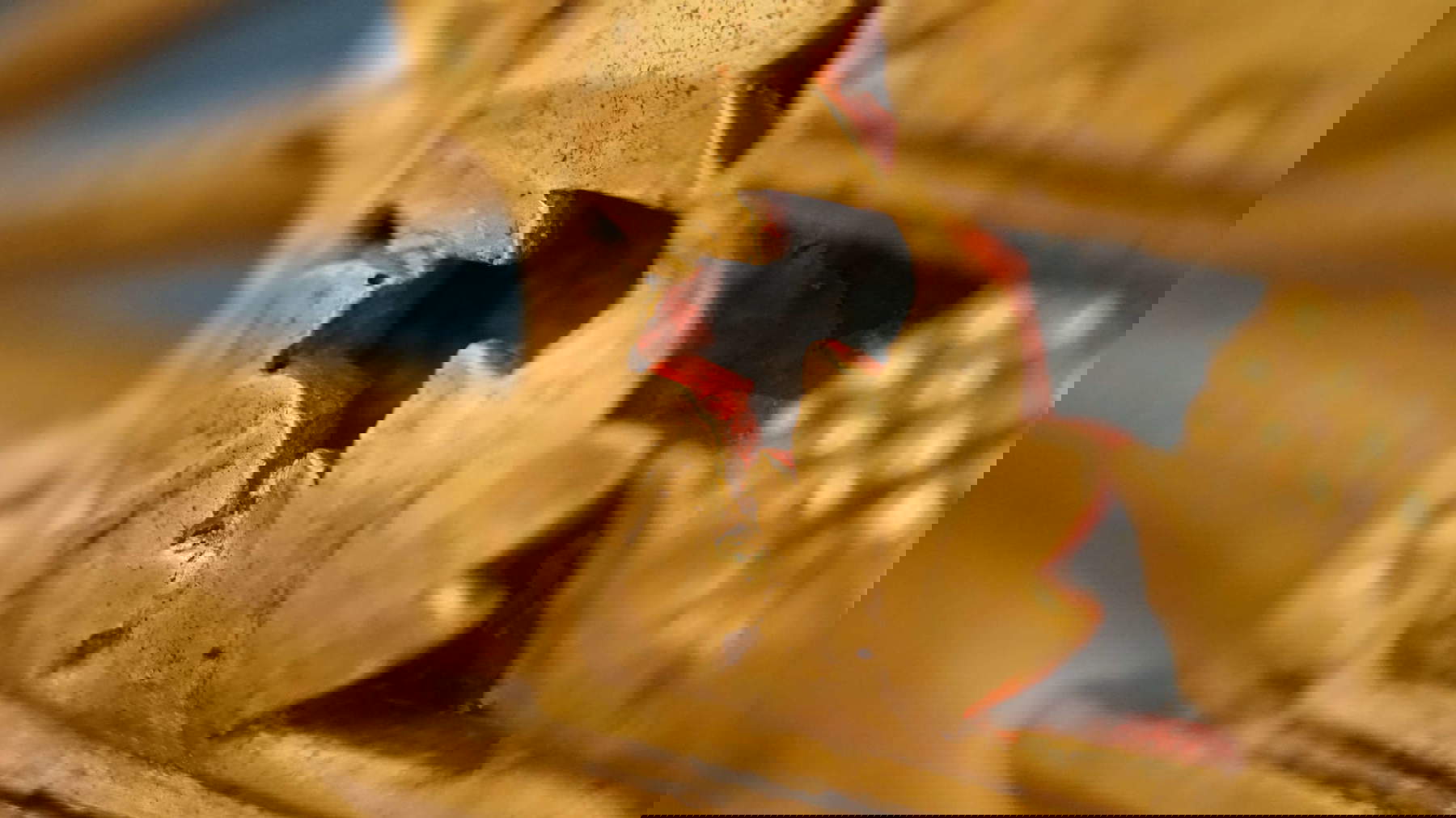 Detalle de fragmentos de la policromía roja original a lo largo de las tallas del marco recuperados durante la última intervención.   Foto: Matteo Panciera Detalle de fragmentos de la policromía roja original a lo largo de las tallas del marco recuperados durante la última intervención.   Foto: Matteo Panciera