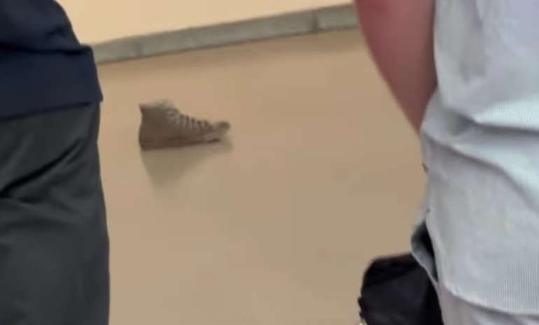 She takes off her shoe and leaves it in a room at the museum: visitors photograph it as if it were a work of art