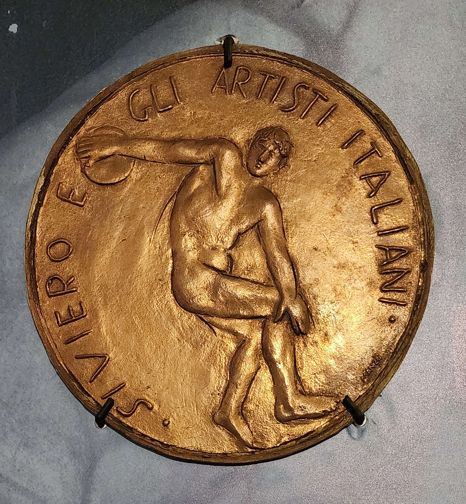 Mario Moschi, Medalla con altorrelieve que representa el Disco Lancellotti (1981; bronce, diámetro 27,3 cm; Florencia, Región Toscana, Casa Museo Rodolfo Siviero) Mario Moschi, Medalla con altorrelieve que representa el Disco Lancellotti (1981; bronce, diámetro 27,3 cm; Florencia, Región Toscana, Casa Museo Rodolfo Siviero)