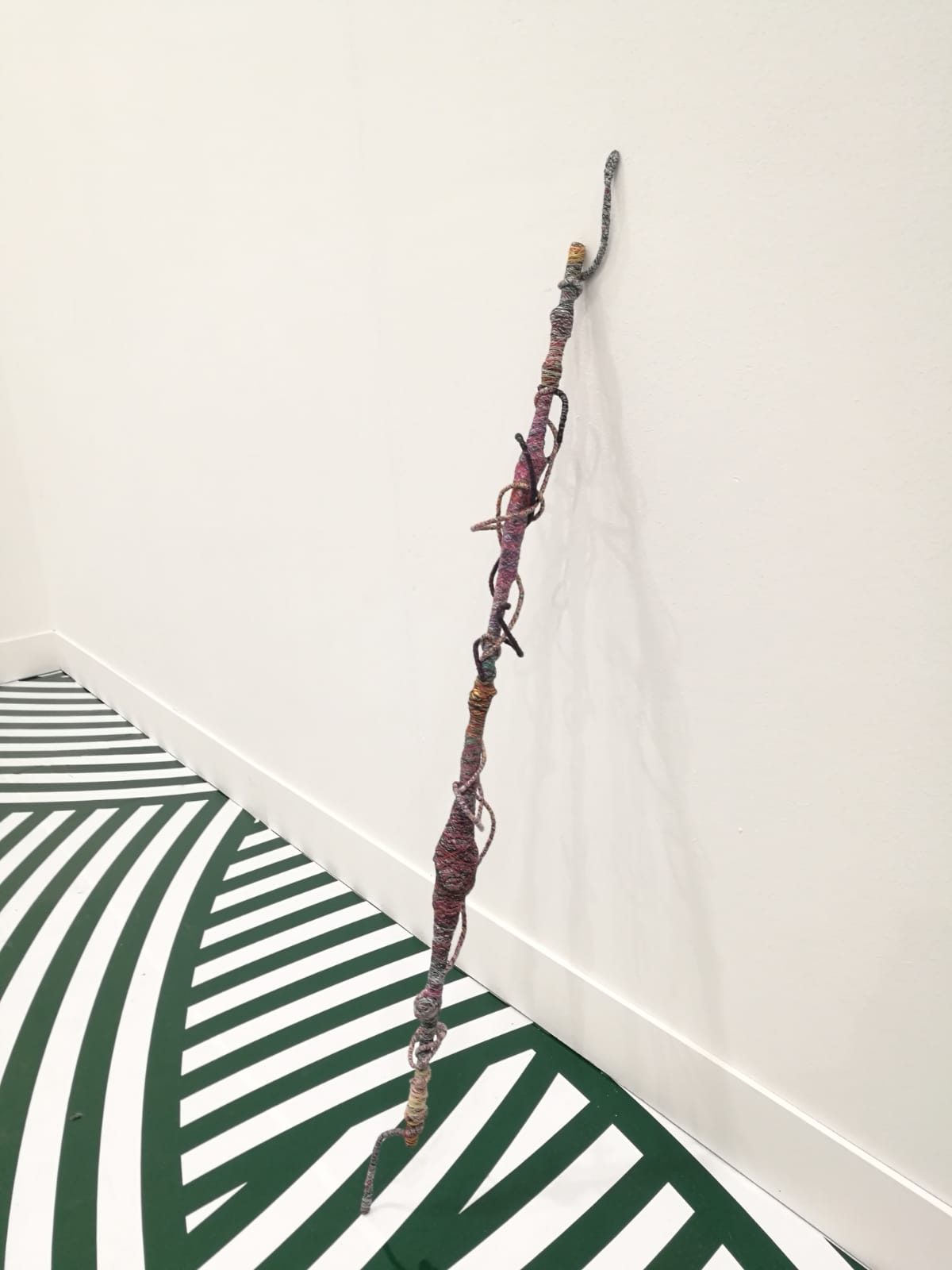 Jim Lambie, Psychedelic Soul Stick 70 (2008; bamb&ugrave;, spago, filo di cotone, collanina di perle, confezione di Marlboro Light, tracolla per borsa, 102 x 9 x 7 cm)