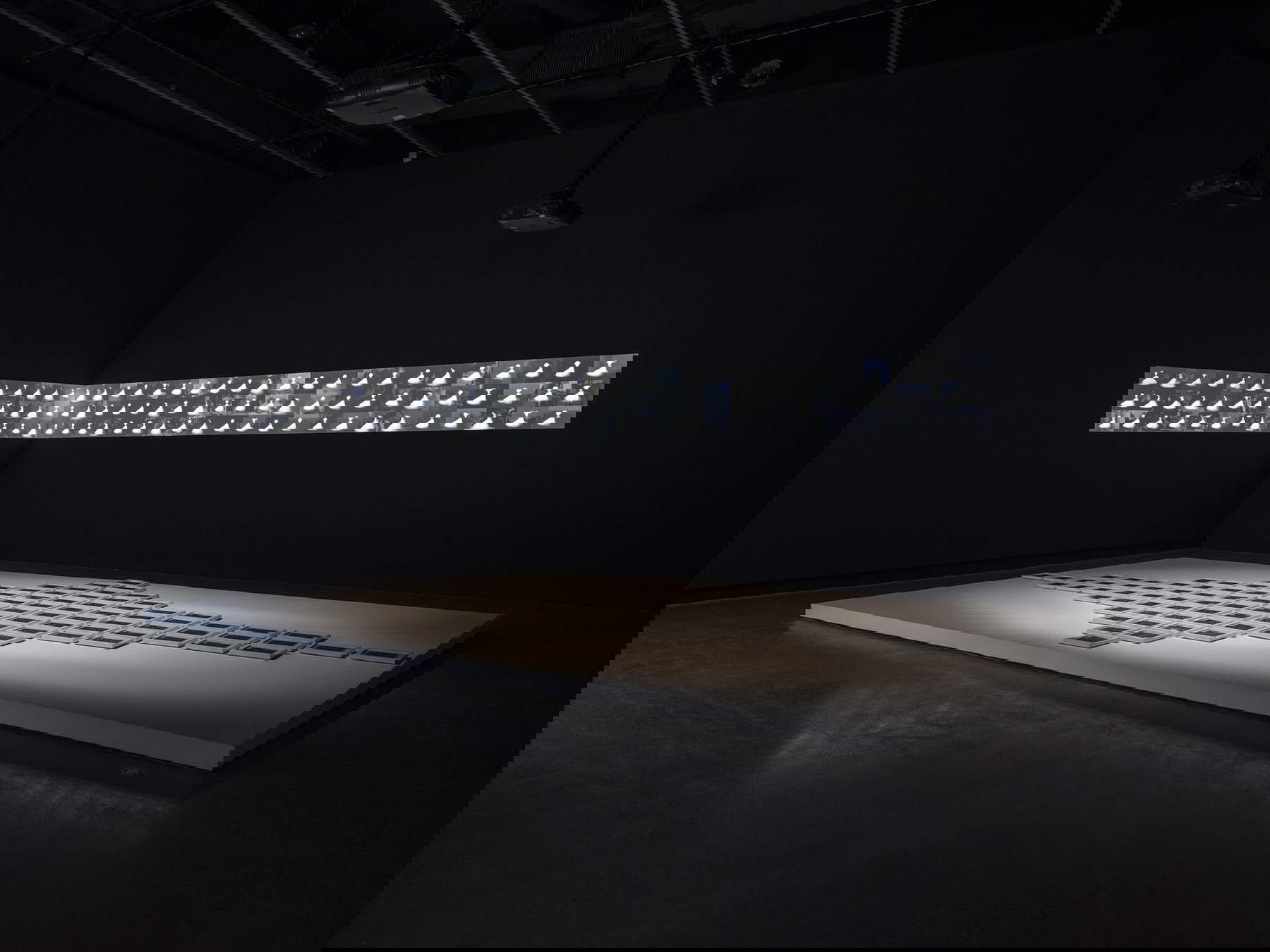 Khaled Sabsabi, 99 (2010; installazione, tre canali video, colore, suono, e 98 dipinti in acrilico, acquerello e gouache su stampe a trasferimento termico a diffusione di colore, incorniciati). Veduta dell'installazione, Destiny Disrupted, GUAM, Brisbane, 2022.