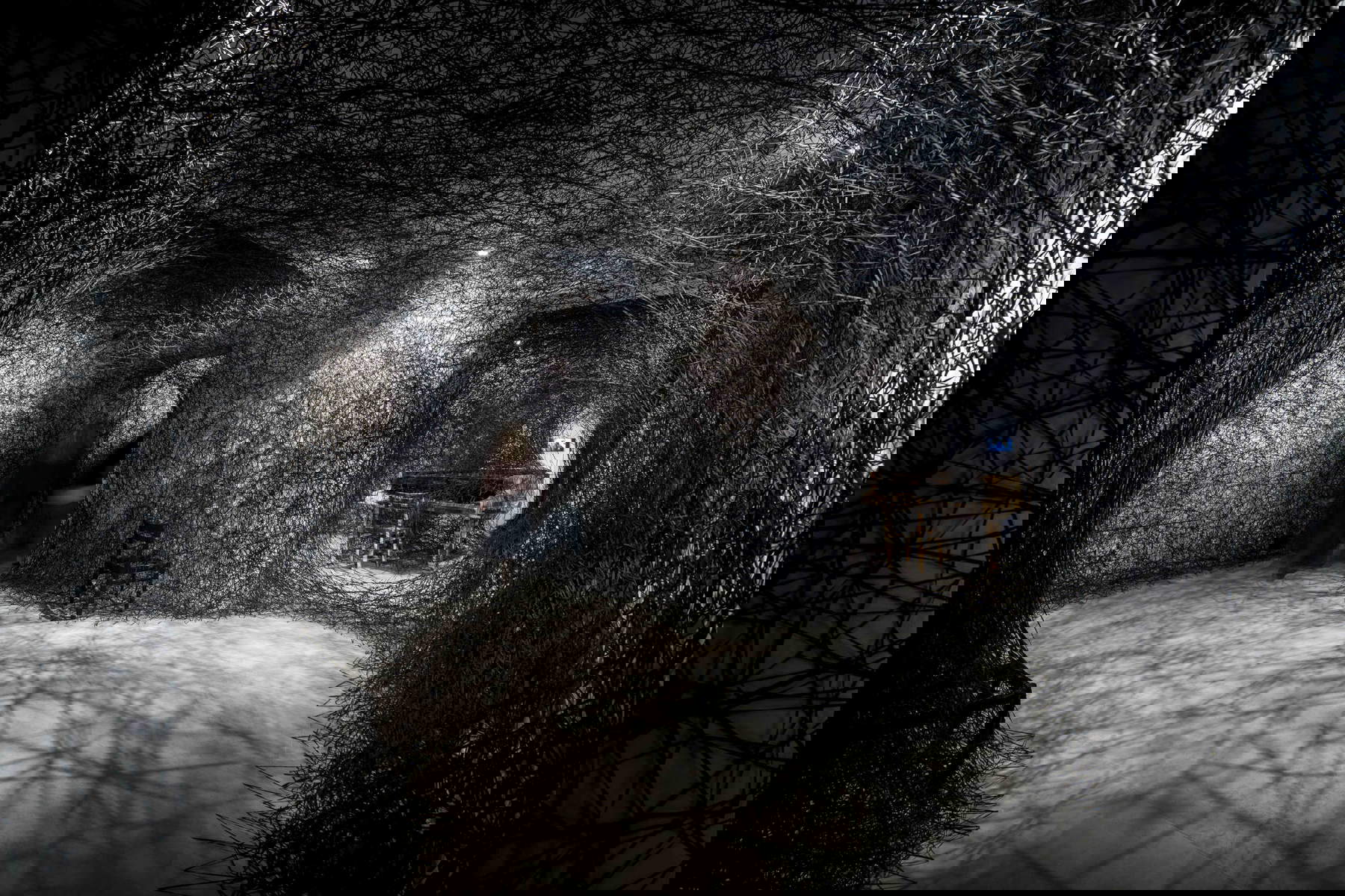 Chiharu Shiota, In Silence (2002-2025; piano quemado, silla quemada, alambre de Alcantara, dimensiones variables). Apoyo a la producción: Alcantara S.p.A. Vista de la instalación en la exposición Chiharu Shiota: The Soul Trembles, MAO Museo d'Arte Orientale, Turín, 2025. Fotografía: Giorgio Perottino. Cortesía del MAO Museo d'Arte Orientale.