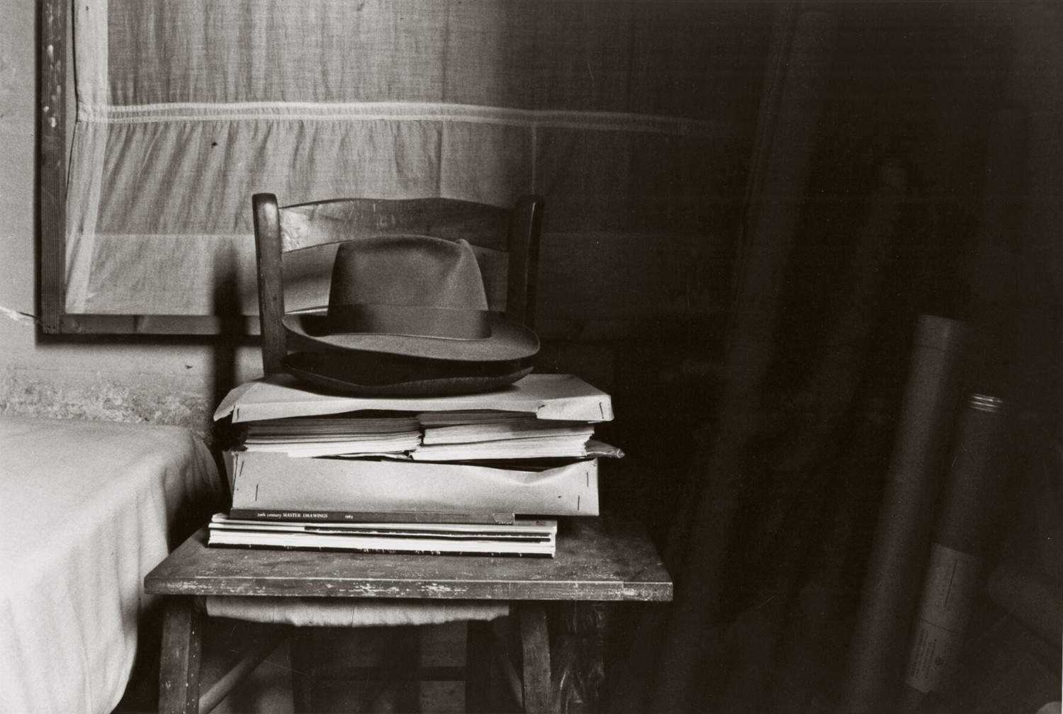 Gianni Berengo Gardin, Il cappello di Morandi e alcuni libri conservati accanto al letto nello studio (1993; stampa ai sali d'argento; Milano, Archivio Gianni Berengo Gardin) © 2025 Gianni Berengo Gardin / Fondazione Forma per la Fotografia / Contrasto