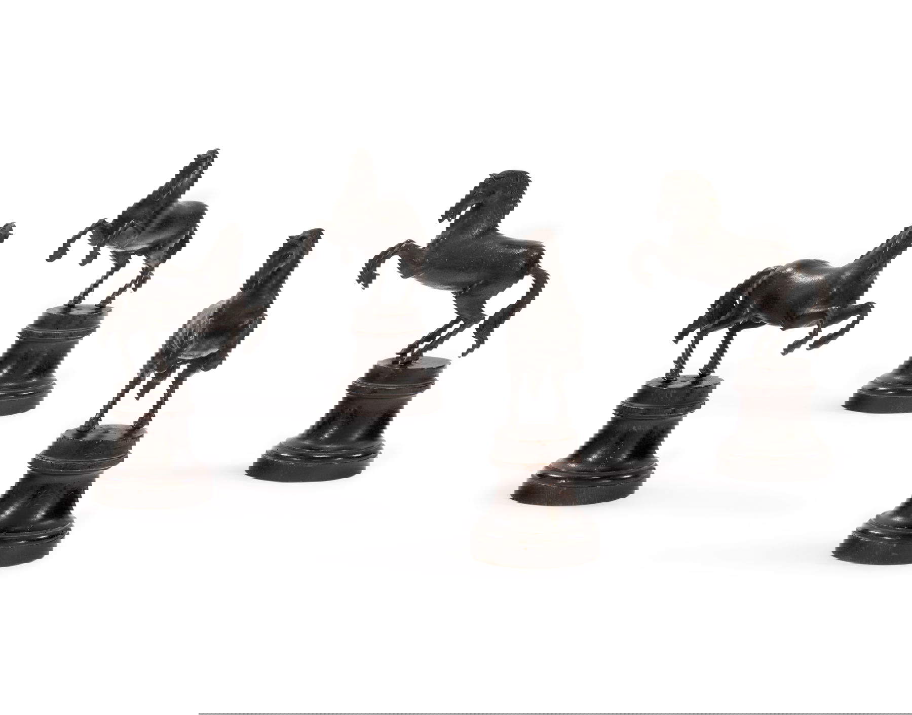 Grupo de cuatro caballos rampantes (s. XVI-XVII; bronce con pátina oscura, fundición a la cera perdida, sobre bases circulares de madera moldeada de fecha posterior, según modelos de Francesco di Virgilio Fanelli; 23 x 16 x 8,5 cm)