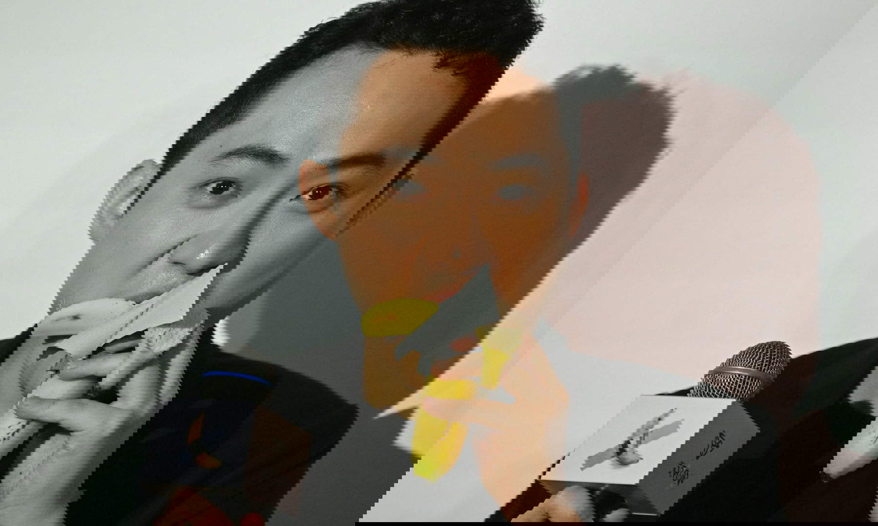 Crypto entrepreneur Justin Sun enjoys the $6.2 million banana purchased from Sotheby's. Photo by Peter Parks / AFP via Getty Images.