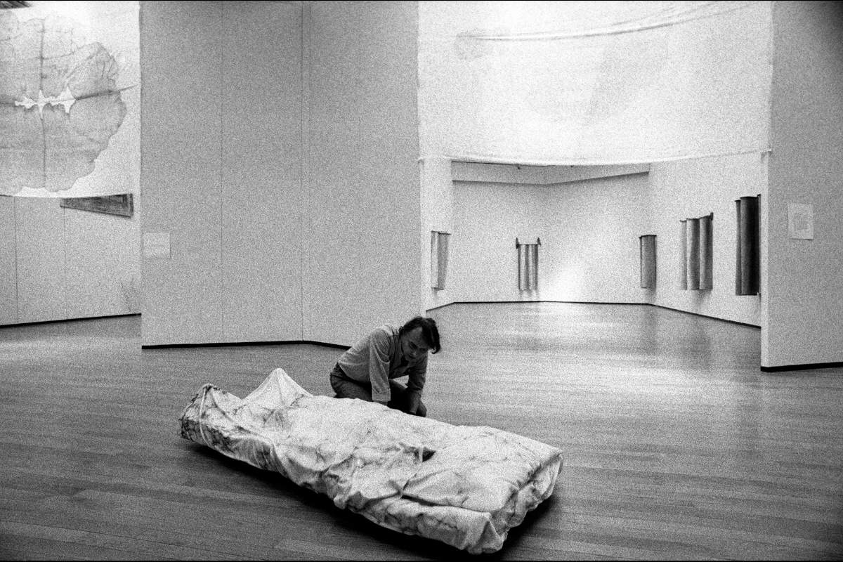 Luciano Fabro con Io rappresento l'ingombro dell'oggetto nella vanit&agrave; dell'ideologia. Lo Spirato, 1968-1973, durante l'allestimento della personale Letture parallele IV, PAC Padiglione d'Arte Contemporanea, Milano, 1980. Su gentile concessione di Archivio Fotografico A.Guidetti e G.Ricci. Foto di Giovanni Ricci