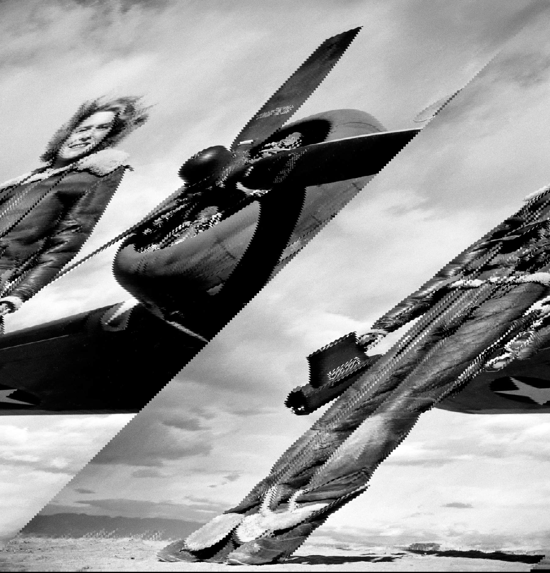 Margaret Bourke-White, photographe de LIFE, vêtue d'une combinaison de vol en polaire et tenant un appareil photo aérien, devant le bombardier Flying Fortress à partir duquel elle a pris des photos en temps de guerre lors de l'attaque américaine sur Tunis. Algérie (1943 ; Margaret Bourke-White/The LIFE Picture Collection/Shutterstock)