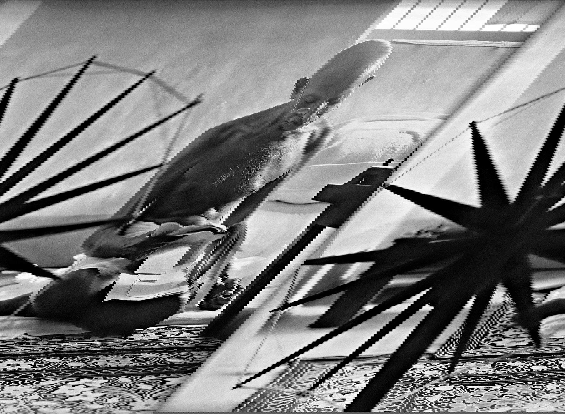 Margaret Bourke-White, Mohandas Karamchand Gandhi lisant près d'un rouet dans sa maison de Pune. Maharashtra, Inde (1946 ; Margaret Bourke-White/The LIFE Picture Collection/Shutterstock)