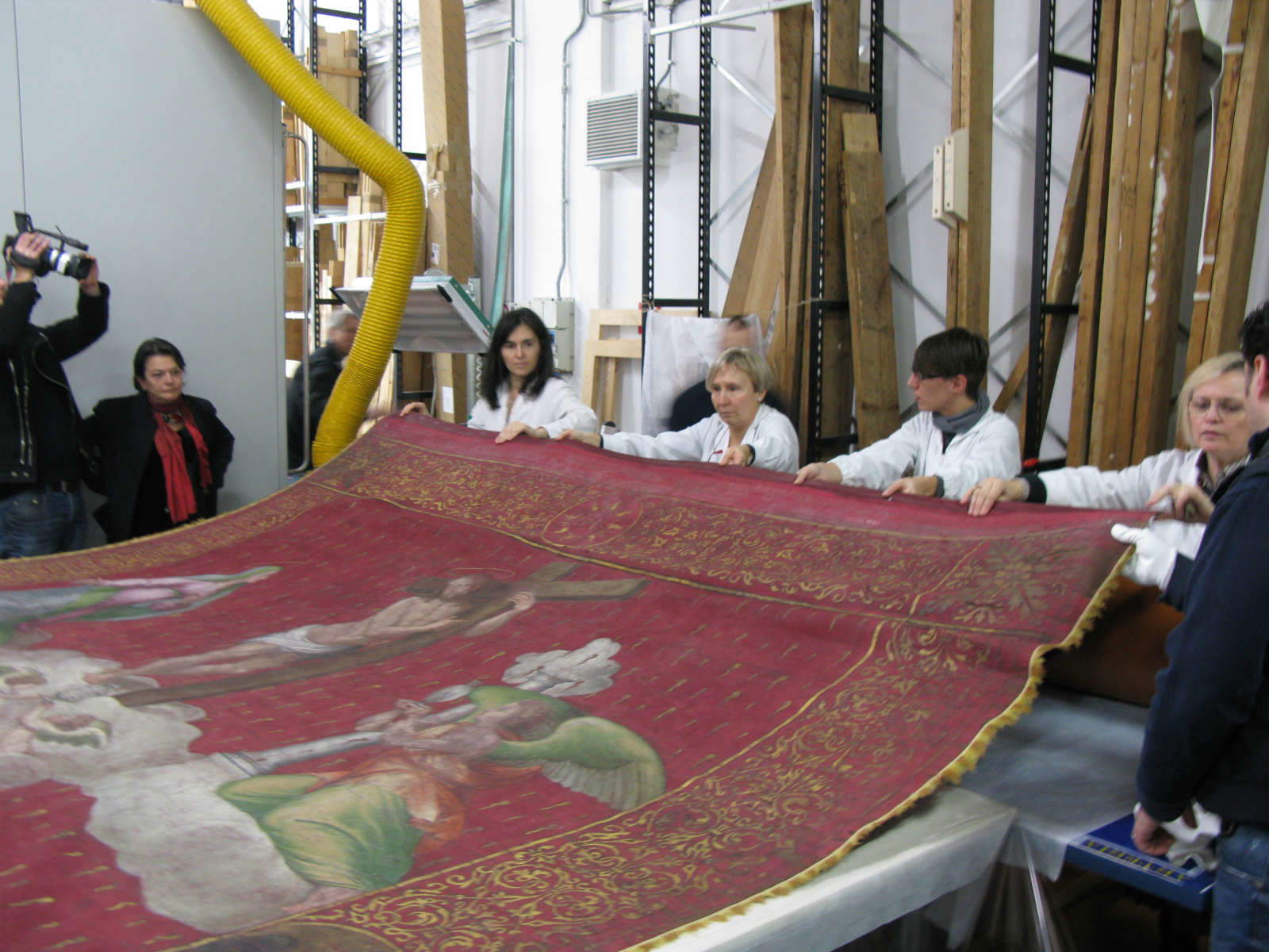 3 décembre 2013. Arrivée du Gonfalone dans les ateliers de la Fortezza da Basso. Les restaurateurs en train de dérouler l'œuvre et de la poser sur la grande table.
