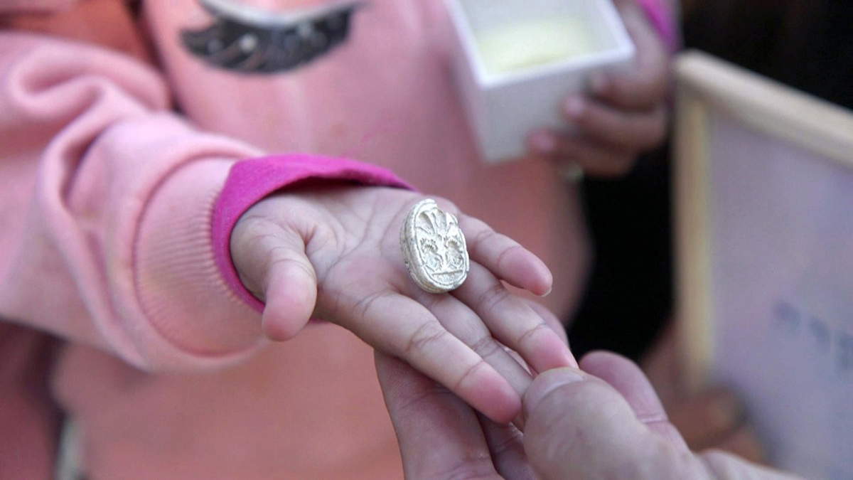 Il sigillo nella mano di Ziv, 3 anni e mezzo. Foto di Emil Aladjem, Autorit&agrave; israeliana per le antichit&agrave; (IAA)