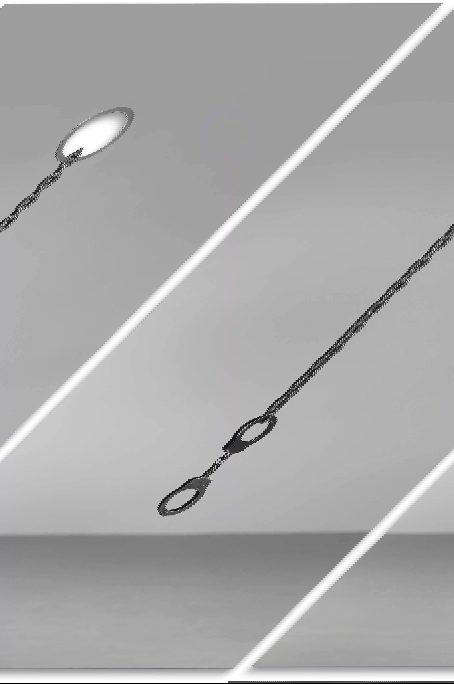 Monica Bonvicini, Love is blind (Black) (2025; espejo de color, acero inoxidable, cadena de acero inoxidable, esposas, 150 x 100 x 8,3 cm). Presentada por: Raffaella Cortese