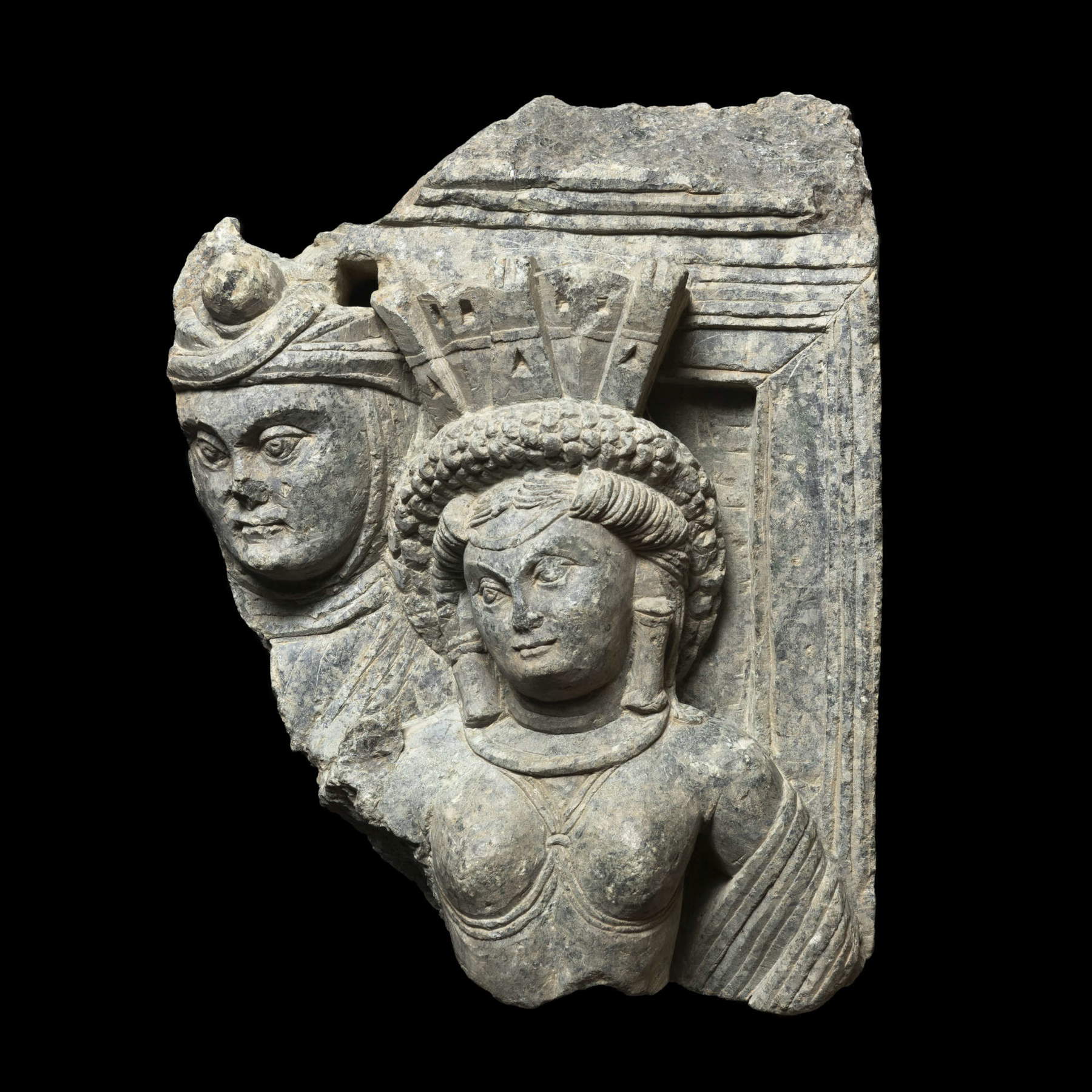 Relieffragment mit einer Gottheit mit Turmhaube und einer männlichen Figur (Butkara I, Swat-Tal, Pakistan, Mitte des 1. Jahrhunderts n. Chr.; Schiefer, 25 x 19 cm; Rom, MUCIV &ndash; Museo delle Civilt&agrave;)