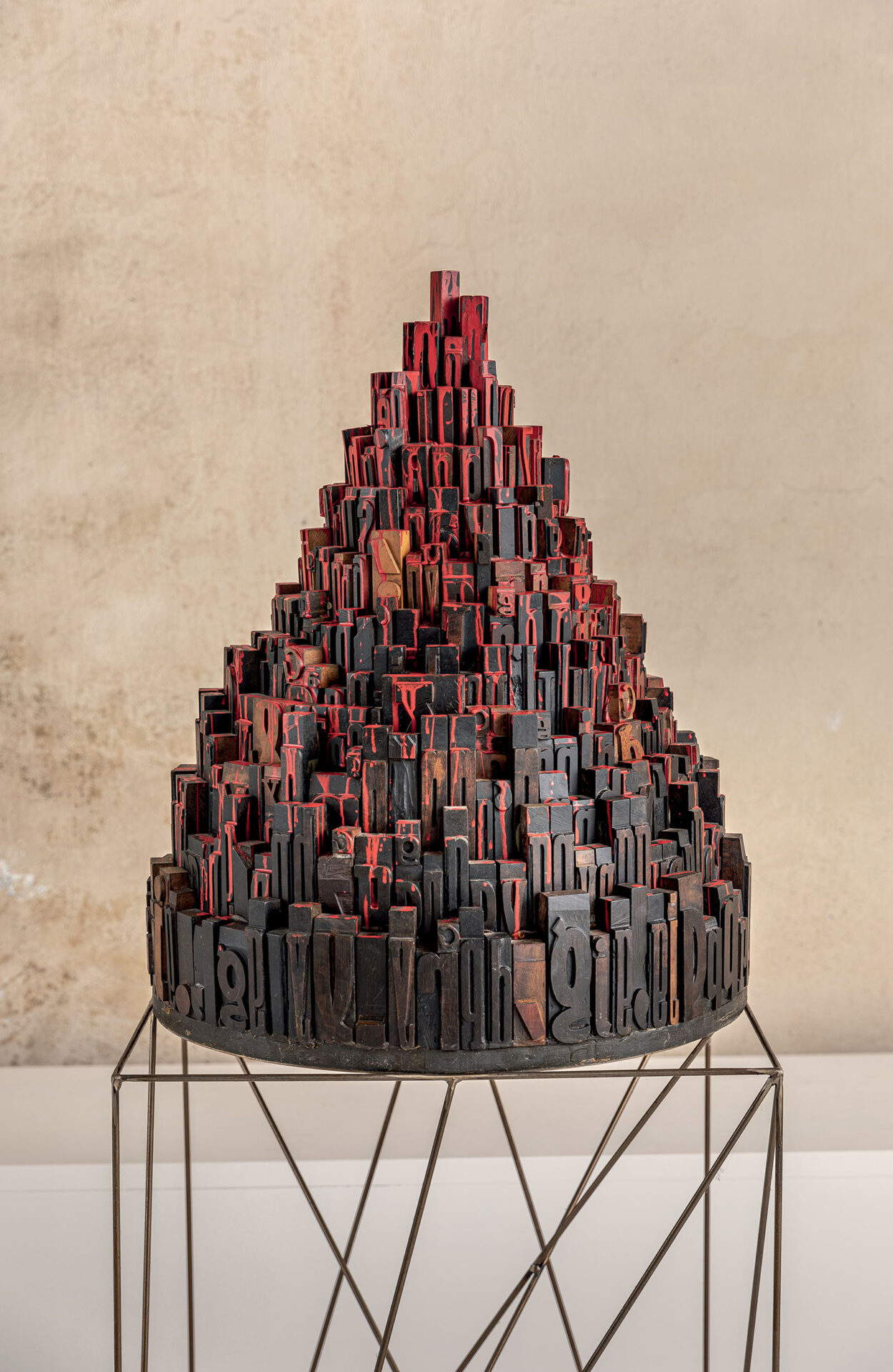 Giorgio Milani, „Babels Turm der Völker, der im Blut der Konflikte mündet“ (Collage aus Holz- und Emaille-Druckbuchstaben, 68 x &oslash; 55 cm)