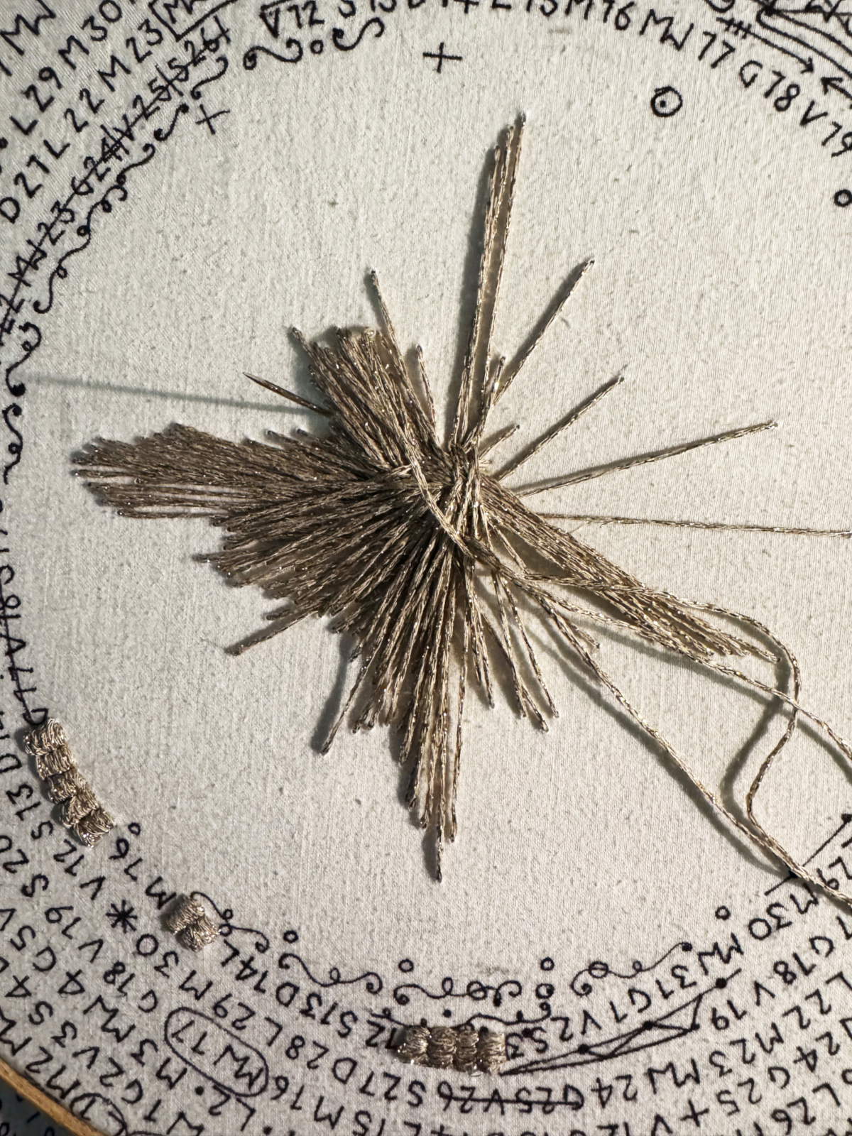 Calendario Luce, detalle (de obra en curso) - bordado en hilo de oro y escritura en tinta sobre hoja enmarcada (2025). Cortesía de la artista