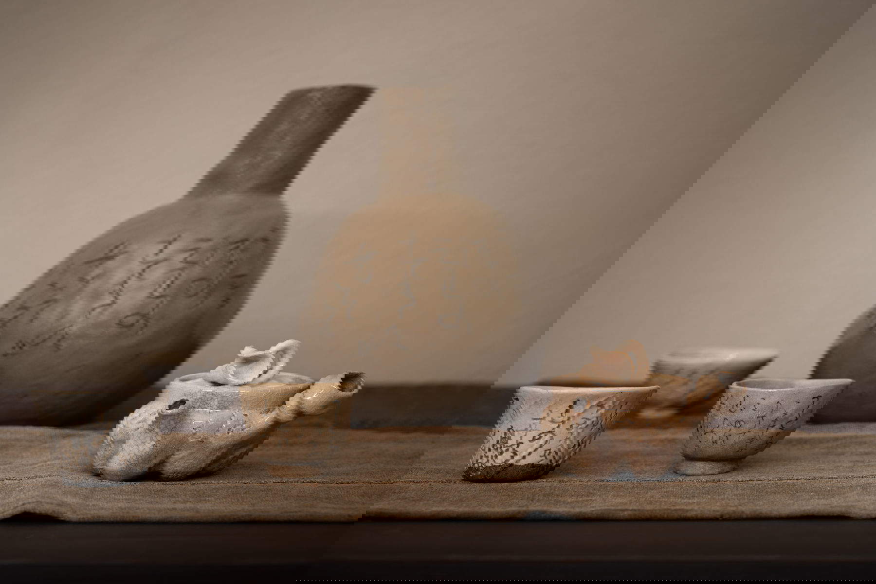 Rengetsu from left: 3 sake bowls with poems; 1 sake bottle, poem 250; 1 teapot, poem 195 (19th century; pottery with engravings) Photo: Tomoyuki Tsuruta