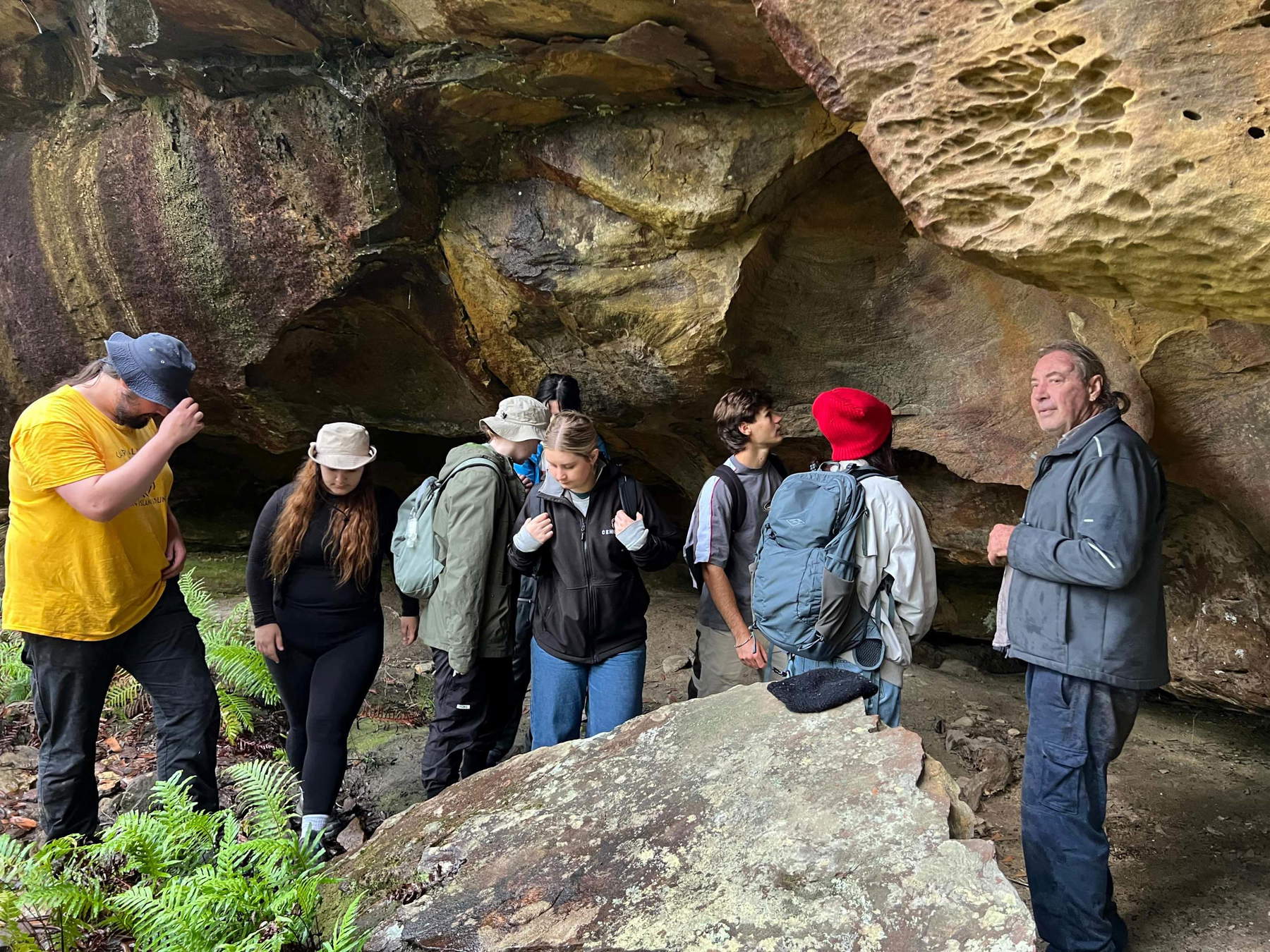 Wayne Brennan (right), an expert in rock art, and some students at one of the cultural sites identified by the drone. Photo: University of Sydney